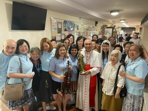 A cardinal receiving the statue of Our Blessed Mother from Flame of Love members